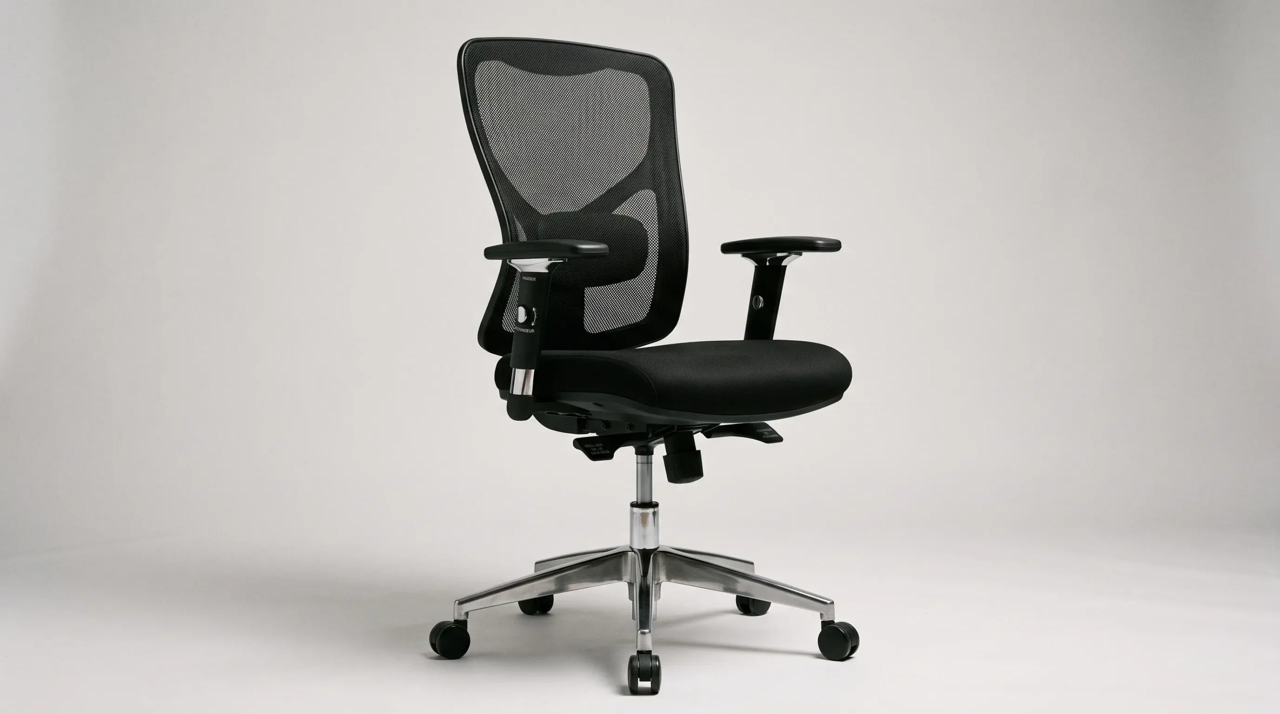 Gros plan trois-quarts d'un siège de bureau ergonomique professionnel noir avec dossier mesh, soutien lombaire visible, accoudoirs réglables et vérin chromé apparent